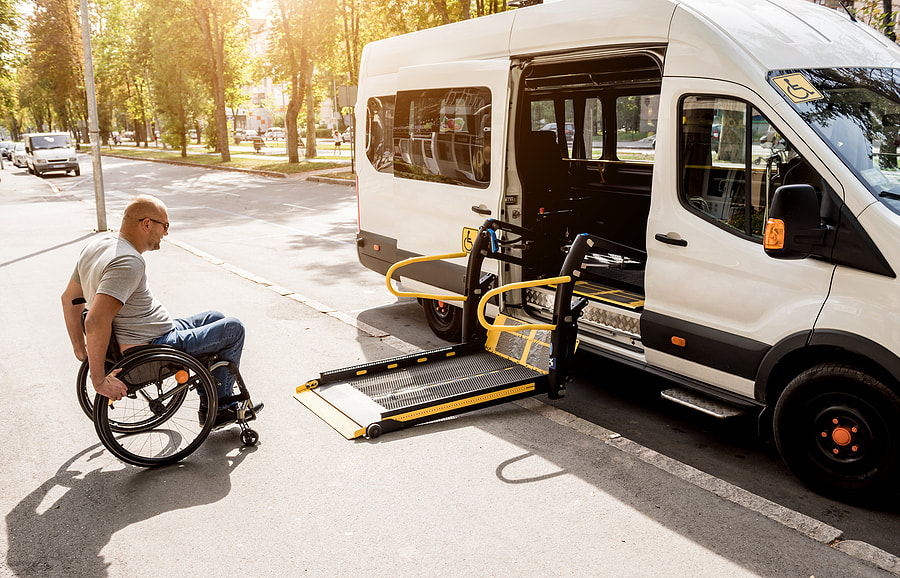 a man sitting in a wheelchair next to a van